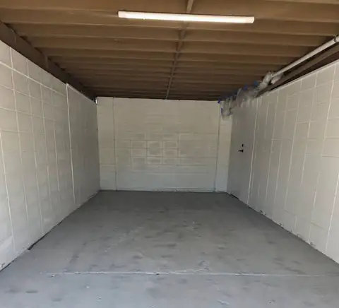 An empty garage with the floor ground back, before repair