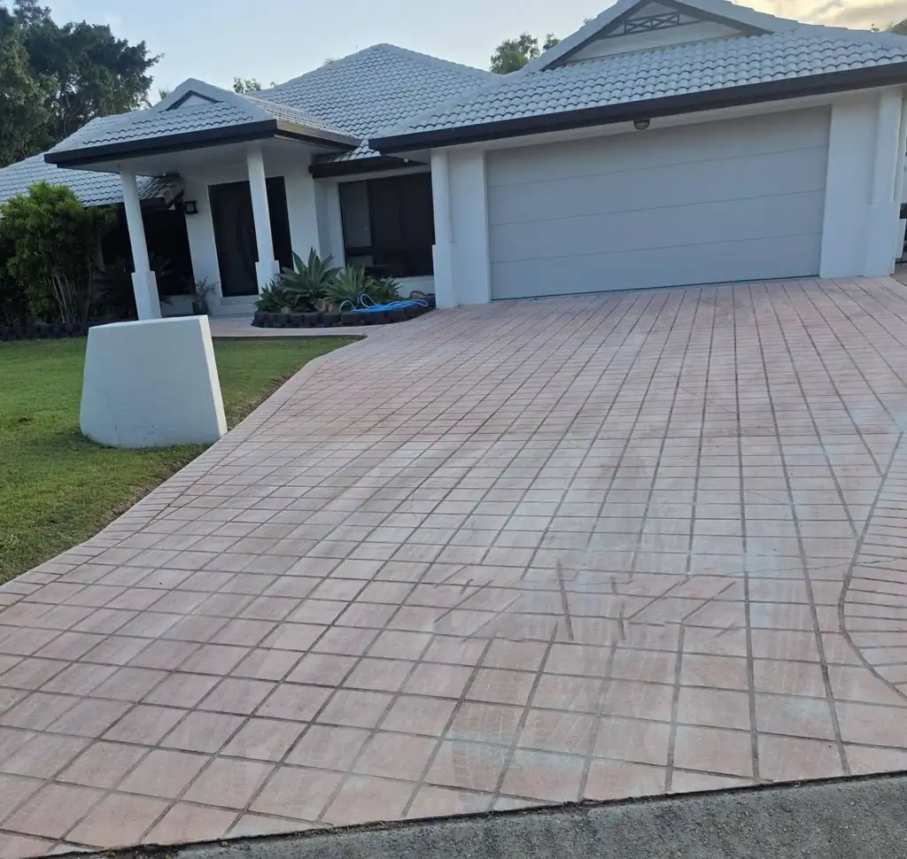 Before: a faded terracotta tile pattern driveway in front of a white house with a double garage